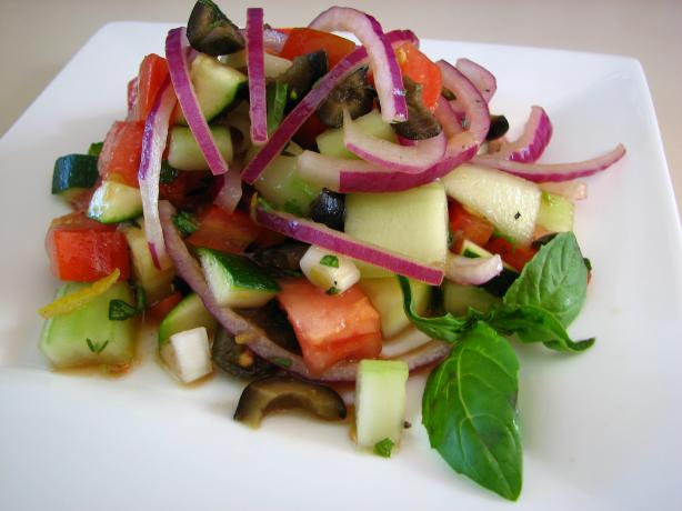 Cucumber Tomato Salad With Zucchini and Black Olives and a Lemon. Photo by Dannyz